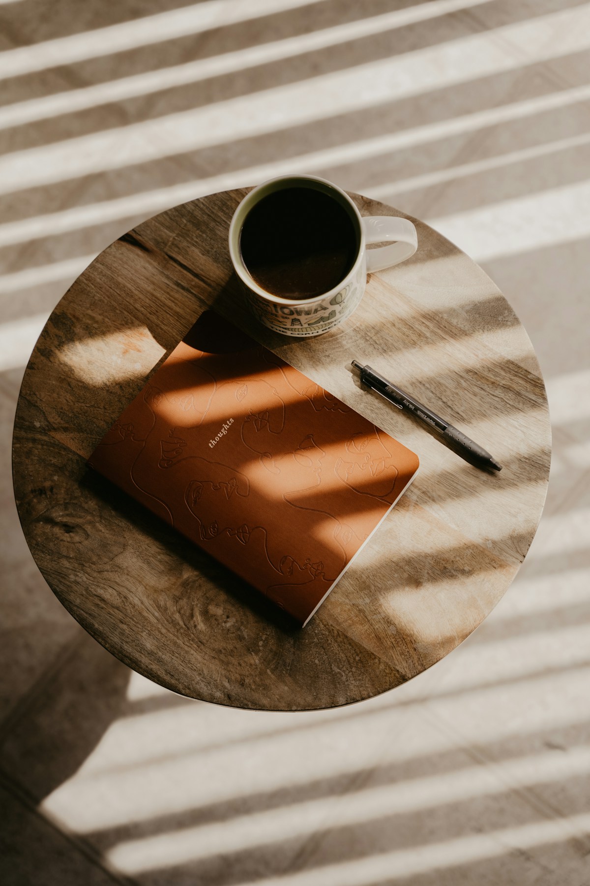 A cup of coffee beside a closed notebook