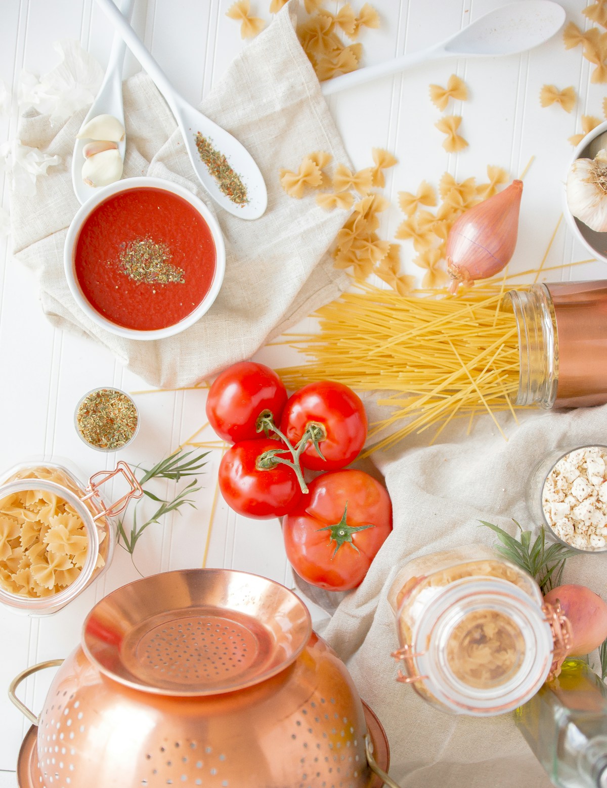 Tomatoes and dry pasta arranged on a rustic table